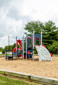 a playground with a slide and climbing equipment in a park
