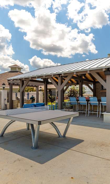an outdoor patio with tables and chairs and umbrellas at Canebrake Apartment Homes, Shreveport, LA 71115