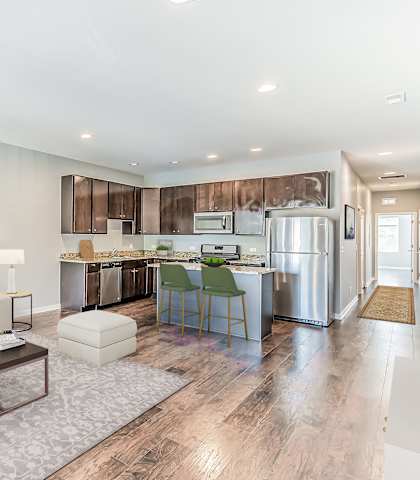 a living room and kitchen with a couch and a table