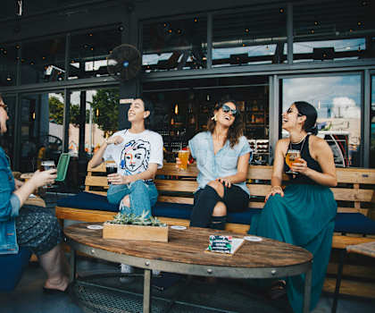 Four friends are sitting around a table in a restaurant.