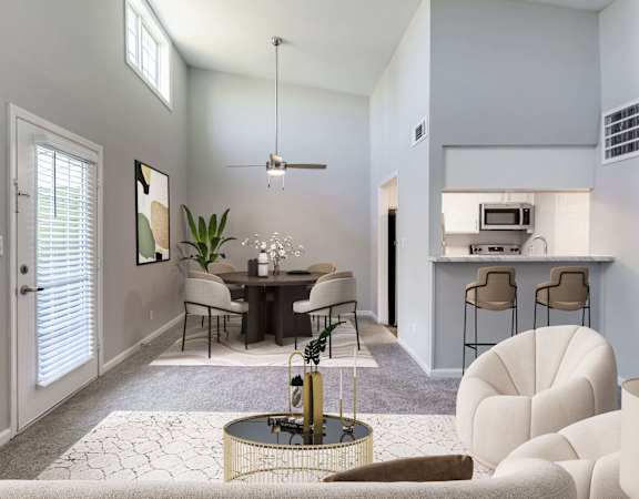 a living room with a dining room and kitchen in the background