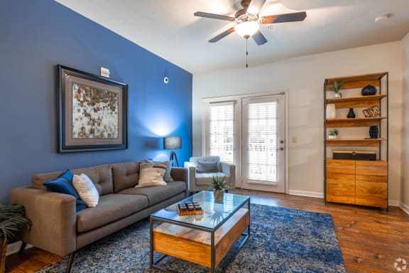 a living room with a ceiling fan and a table and chairs  at Landing at Willow Bayou Apartment Homes, Bossier City, LA