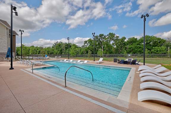 A large outdoor swimming pool with lounge chairs and umbrellas.