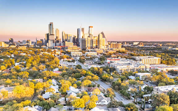 A cityscape with buildings and trees in the foreground.