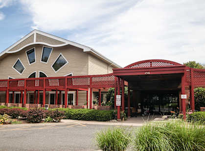 the front of a building with a red porch and awning