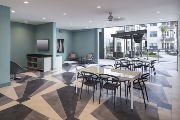 a dining room with tables and chairs and a tv at Gatsby on Ross, Dallas, 75204