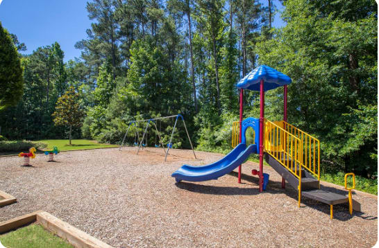 A playground with a blue slide and yellow railings.