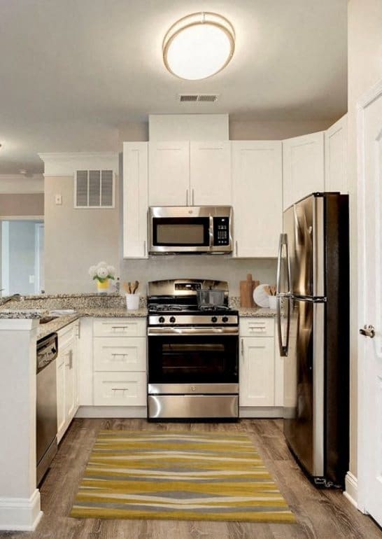a kitchen with stainless steel appliances and white cabinets