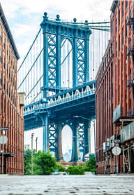 a view of the empire state building from under the bridge
