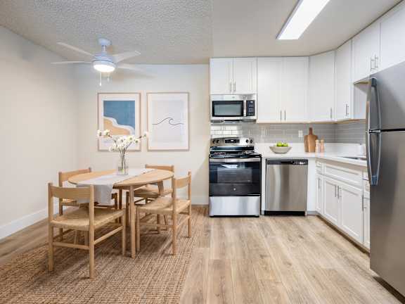 A kitchen with a table and chairs and a refrigerator.