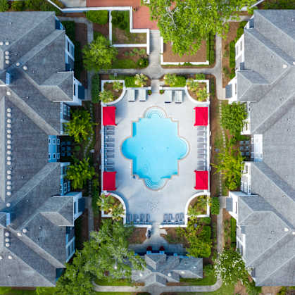 A bird's eye view of a residential area with houses and a swimming pool.