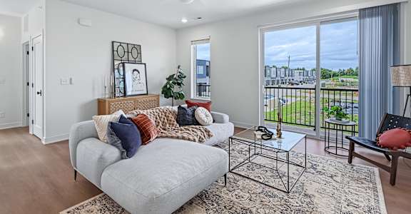 Living room with cozy couch at The Flats at West Glen Apartments, West Des Moines, IA, 50266