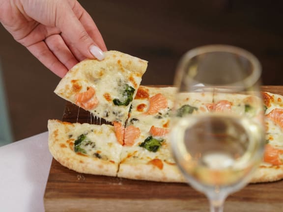 a person holding a glass of wine and a plate of food