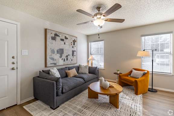 A living room with a grey couch, a coffee table, and a painting on the wall. at Highland Park, Texas, 76132