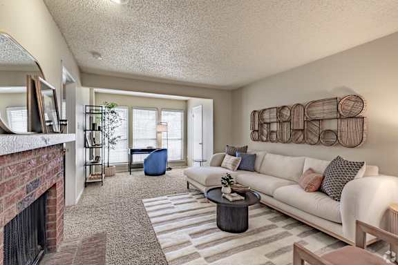 A living room with a fireplace and a couch. at Highland Park, Texas, 76132