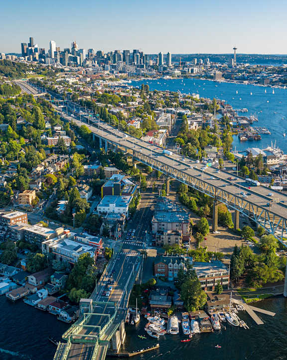 A cityscape with a bridge over a river filled with boats.
