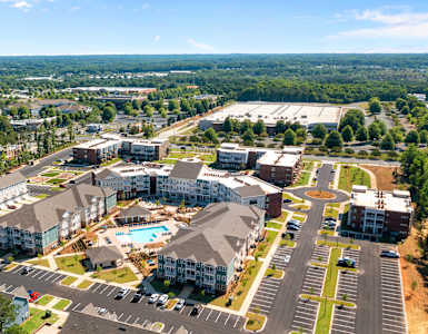 an aerial view of a city with buildings and trees at The Address Galleria, Matthews, NC, 28105