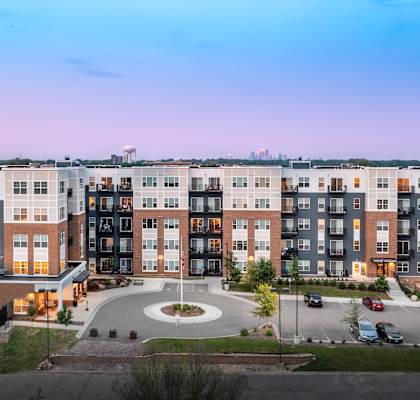 an exterior view of an apartment building at dusk