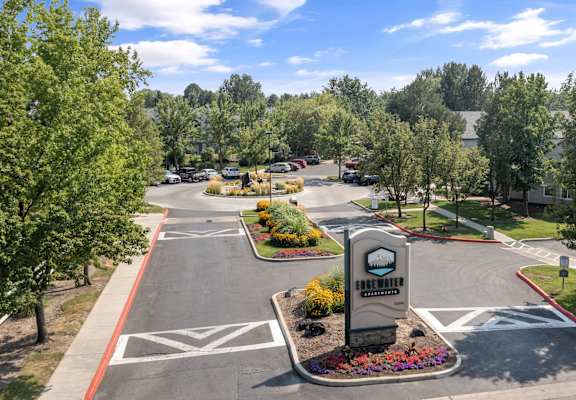 an aerial view of a parking lot with trees and a sign at Edgewater Apartments Boise, Boise, 83703