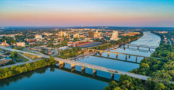 A cityscape with a river and a bridge.