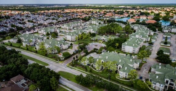 an aerial view of a neighborhood with green roofs and trees