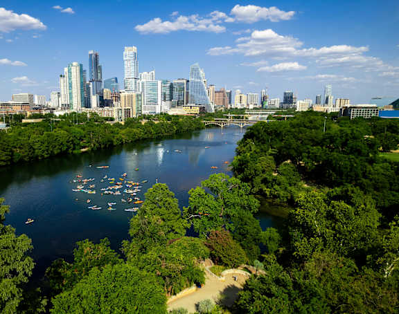 an aerial view of a river with a city skyline in the background