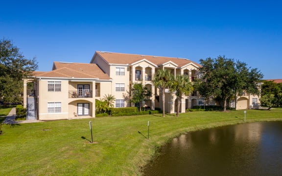 exterior of 3 story apartment building near lake at Cypress Legends, Fort Myers