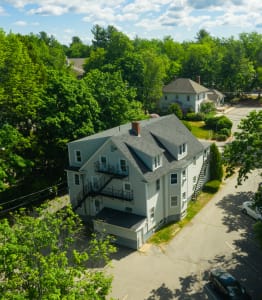 an aerial view of a large white house surrounded by trees