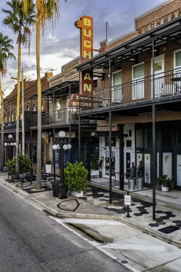 a rendering of people walking on a sidewalk in front of apartment buildings at Casa Marti, Tampa, FL