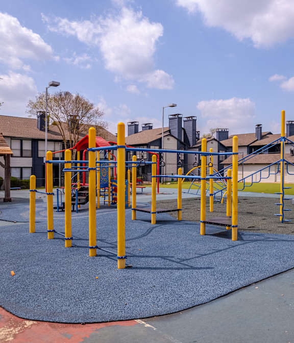 an empty playground at a neighbourhood park with houses