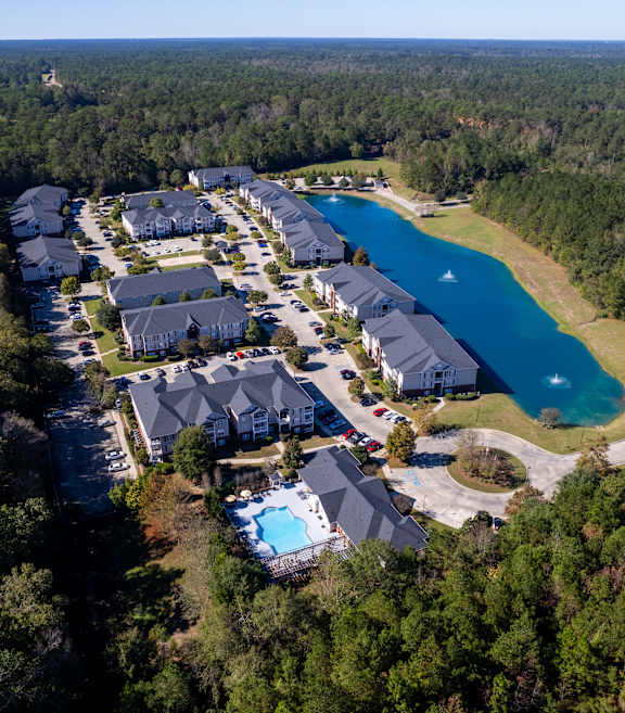 A bird's eye view of a resort with a swimming pool and a lake.