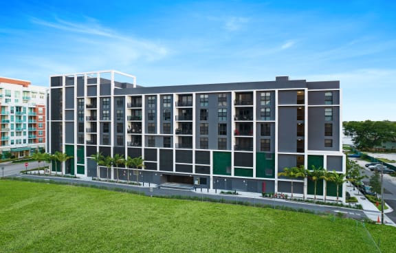 a large building with many windows and a grassy area in front of it