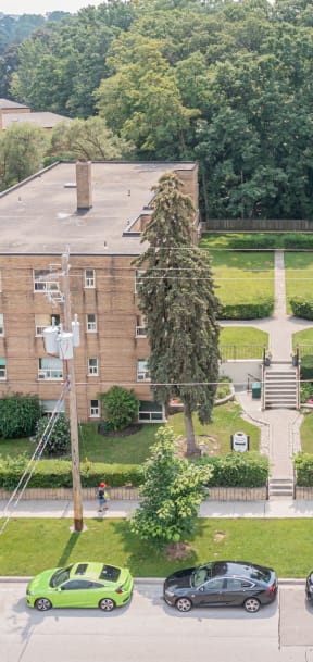 a view from above of a large brick building with cars parked in front of it