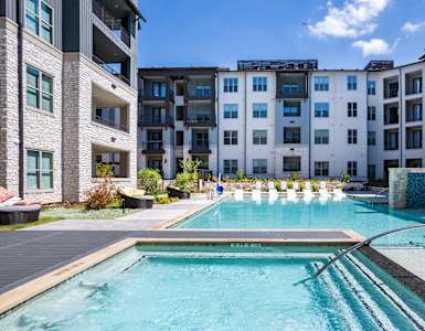 a swimming pool with an apartment building in the background