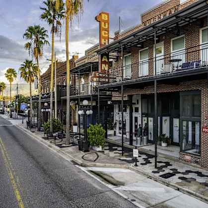 a street with palm trees and buildings on the side of a road