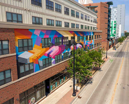 a city street with a mural on the side of a building