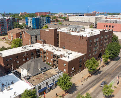 a view from above of a brick building with a white roof and a blue building behind it