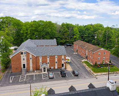 arial view of a brick building with trees in the background