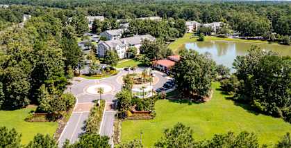 A bird's eye view of a roundabout in the middle of a green residential area.