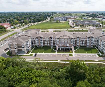 A large apartment complex with a parking lot in front.