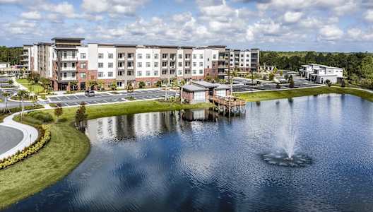 an aerial view of a lake with apartments in the background at The Haven at Lake Britt Apartments, Winter Garden, FL 34787