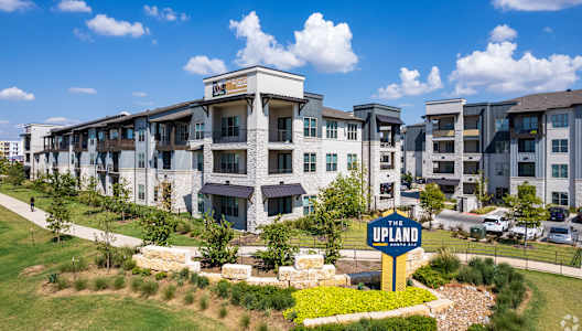 A large building with a sign that says "UPLAND" in front of it.