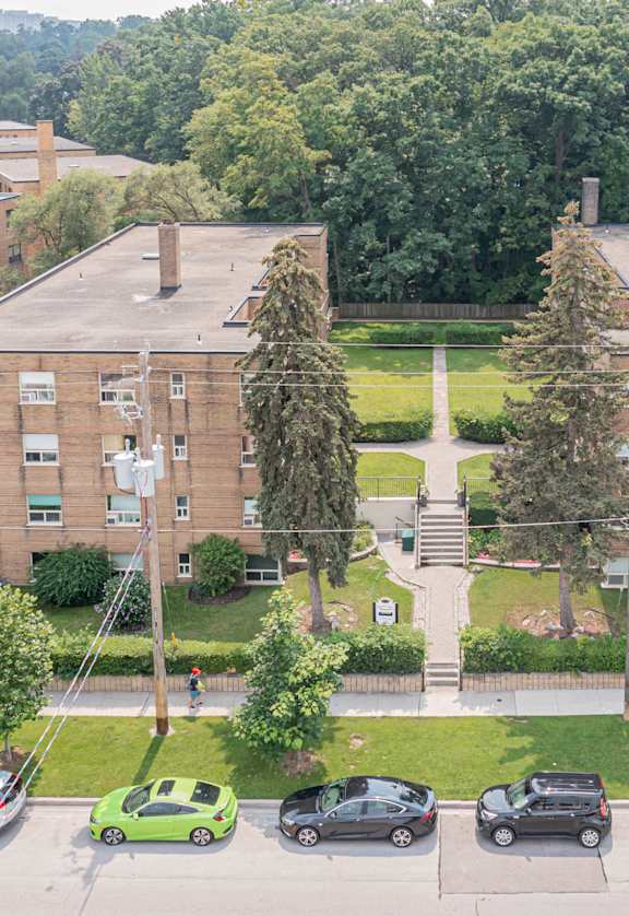 a view from above of a large brick building with cars parked in front of it