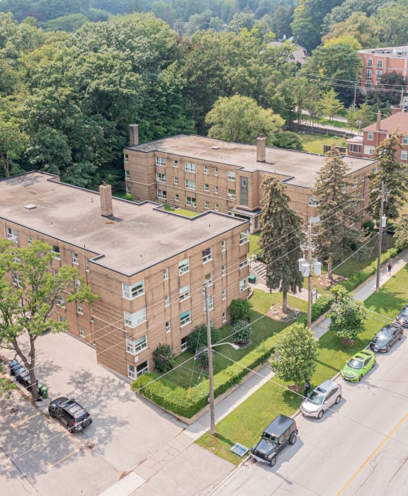 an aerial view of a brick building with cars parked on the side of the road