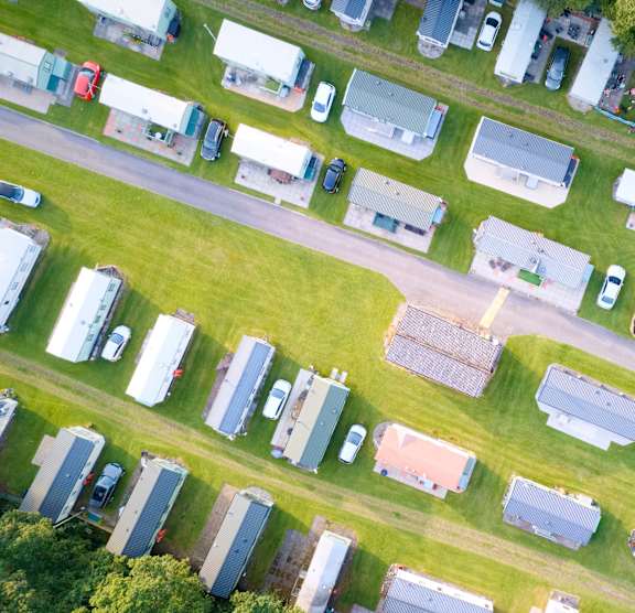 A field of RVs and trailers parked in a lot.