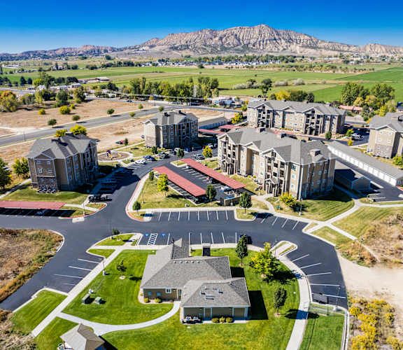 A large, modern building complex with a parking lot in front.