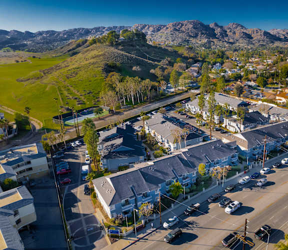 an aerial view of a parking lot with mountains in the background