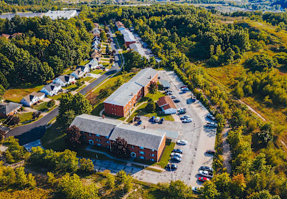 an aerial view of a building and parking lot with trees