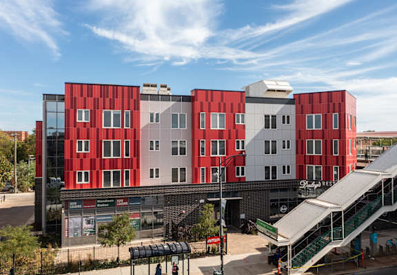 A red and white building with a green staircase in front.