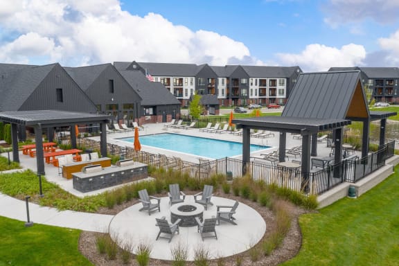 a large swimming pool with patio furniture in front of a building